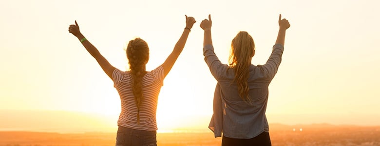 two girls holding their thumbs up